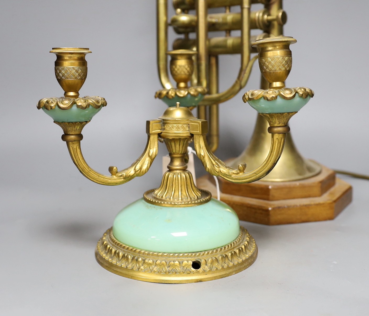 A novelty brass trumpet table lamp and three sconce brass candelabra, trumpet lamp 44cms high including fitting